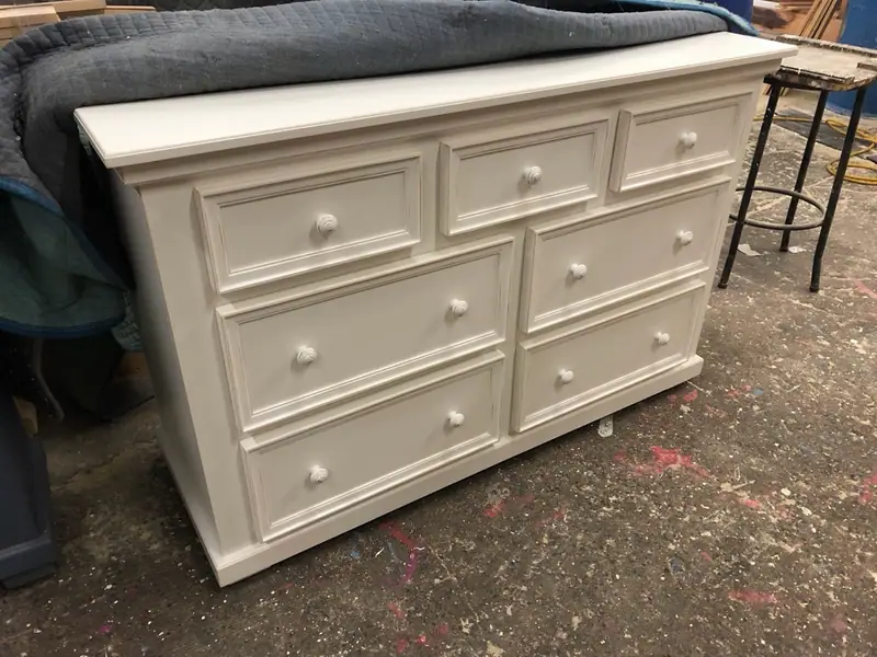 Commode de sept tiroirs de largeurs inégales, façades à panneaux carrés moulurés et boutons cannelés.
