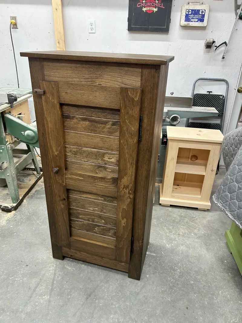 Armoire Monaco haute et étroite à une porte, dessus à tête carrée sans moulure, panneaux de lambris posés à l’horizontale.