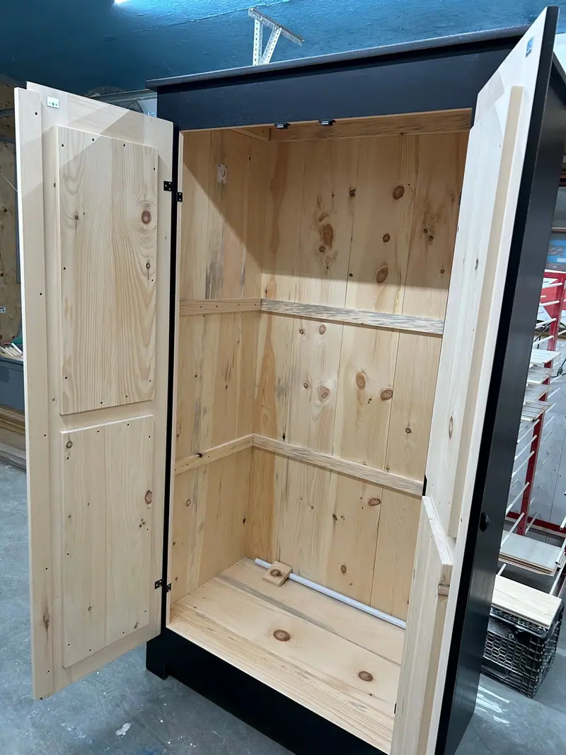La même armoire Monaco ouverte : intérieur entièrement en pin massif, tablette et pôle de penderie livrés avec le meuble.