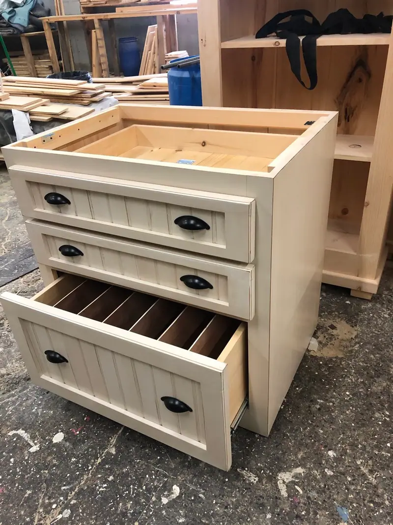Armoire en pin aux tiroirs texturés, fabriqués comme des portes lambris.